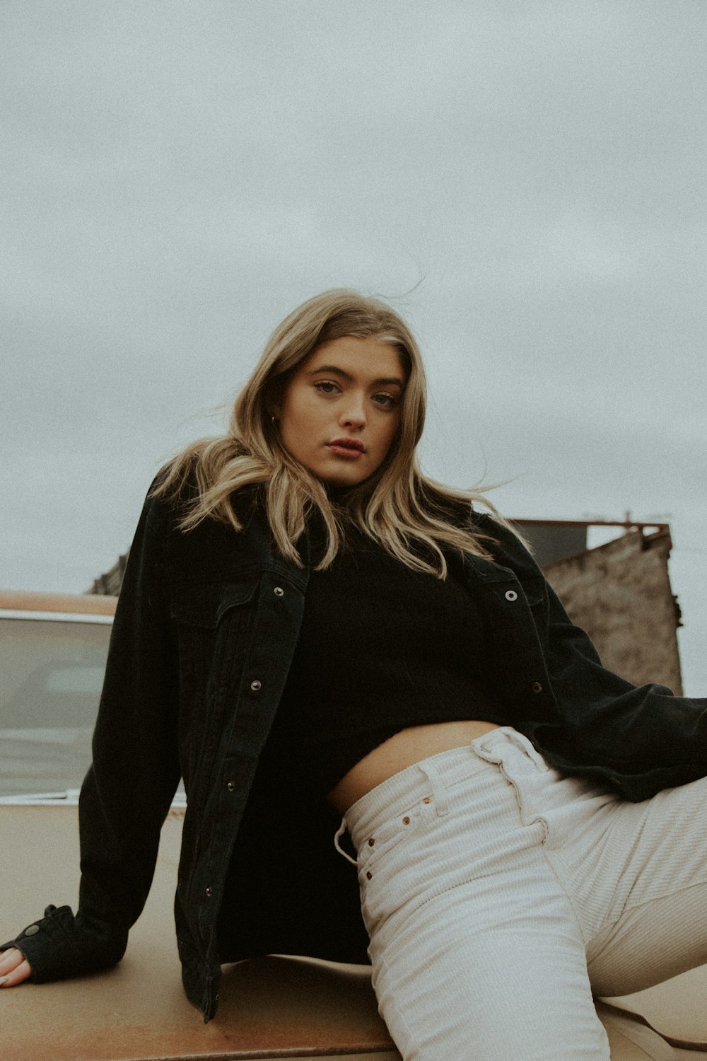 woman in black jacket and white denim jeans