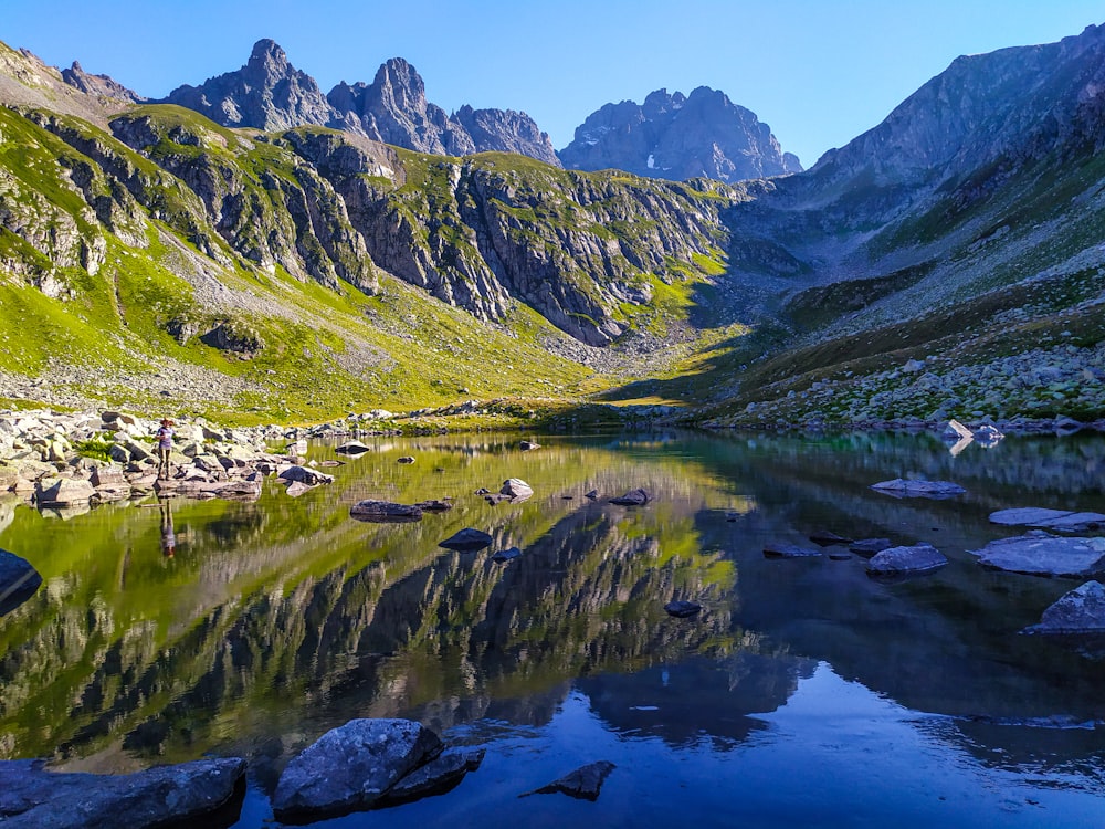 green and brown mountains beside lake during daytime