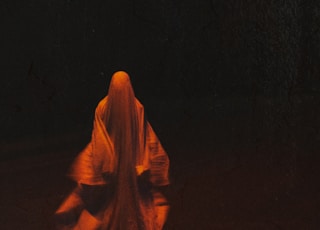 woman in orange hijab standing on black surface