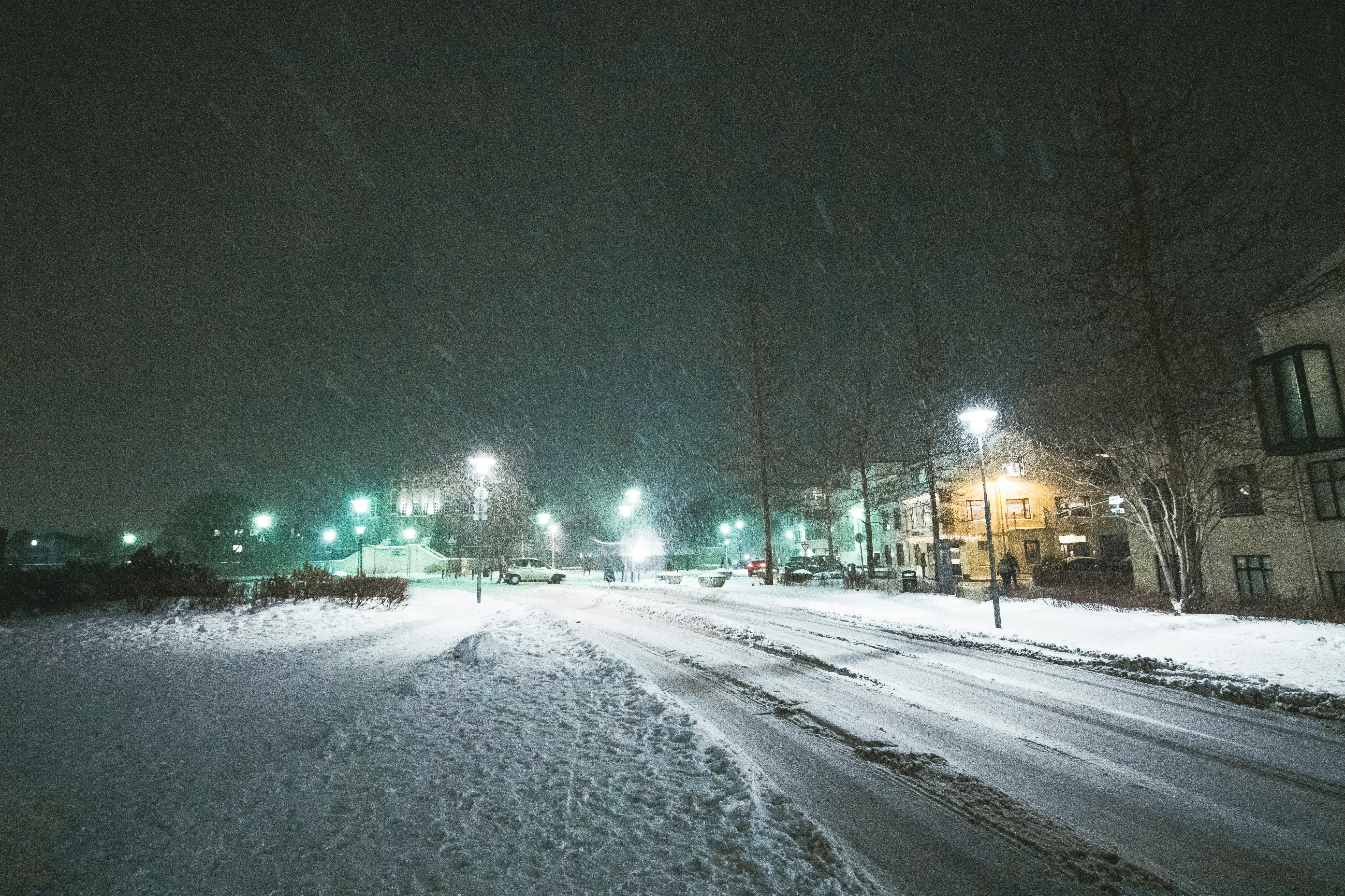 snow-covered-road-during-night-time