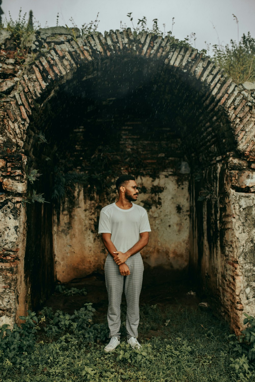 woman in white crew neck t-shirt and gray pants standing on tunnel