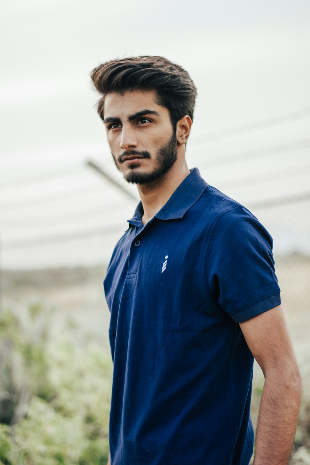 man in blue polo shirt standing during daytime