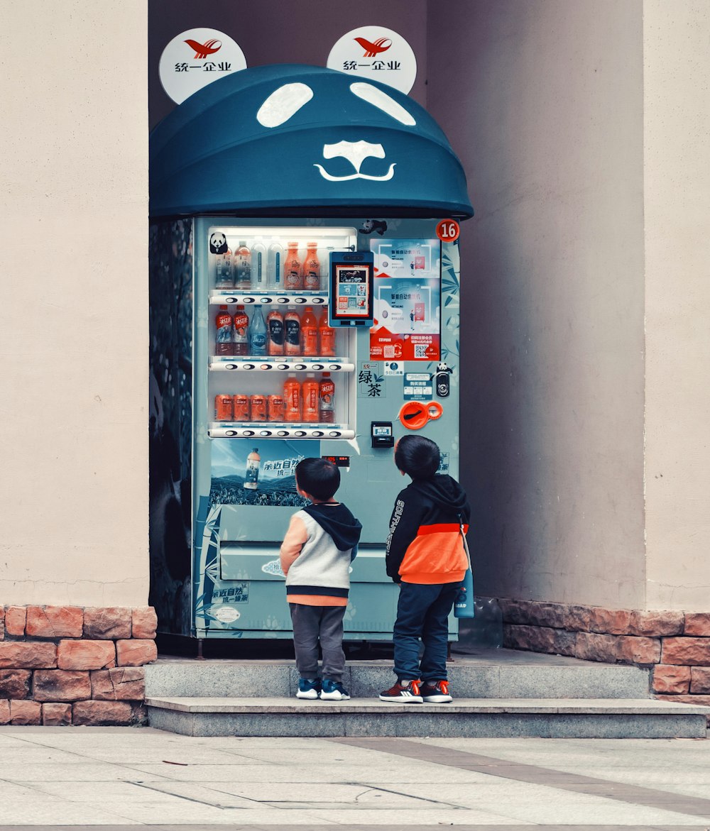 man in black and red jacket standing beside pepsi vending machine