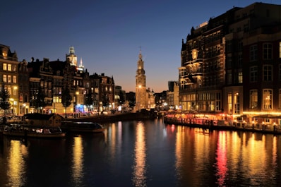 boat on river near city buildings during night time