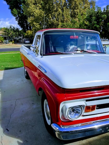 A close-up of a well-maintained pickup truck parked in front of a cozy farmhouse.