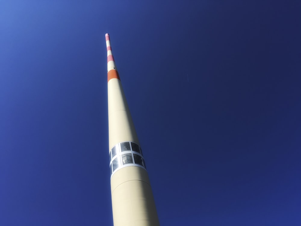 a tall white tower with a red and white stripe on it