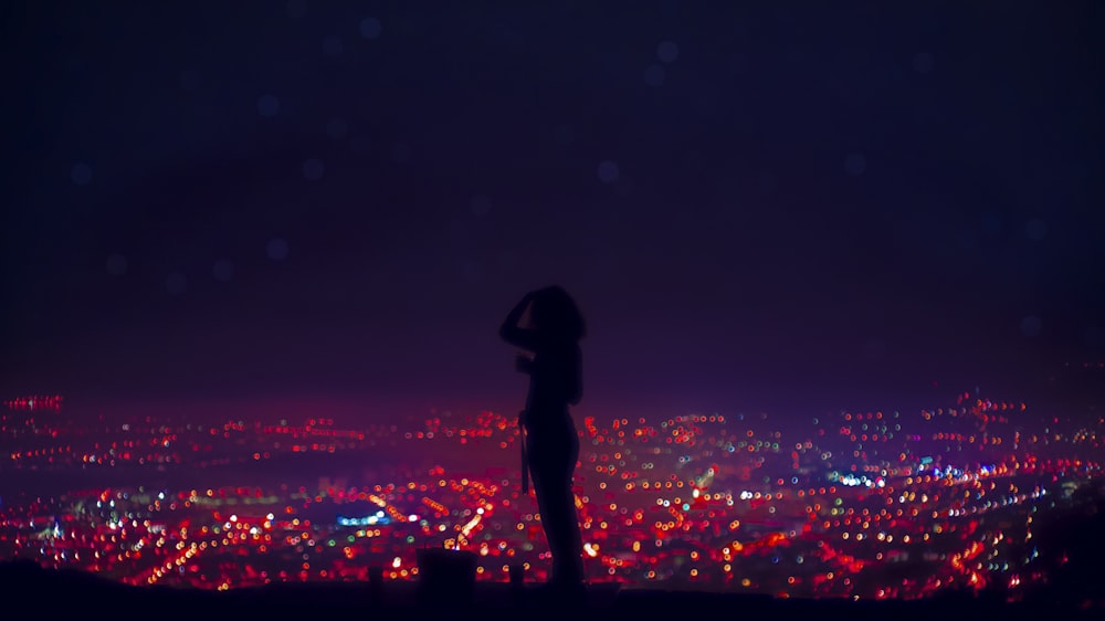 silhouette of woman standing on the ground during night time