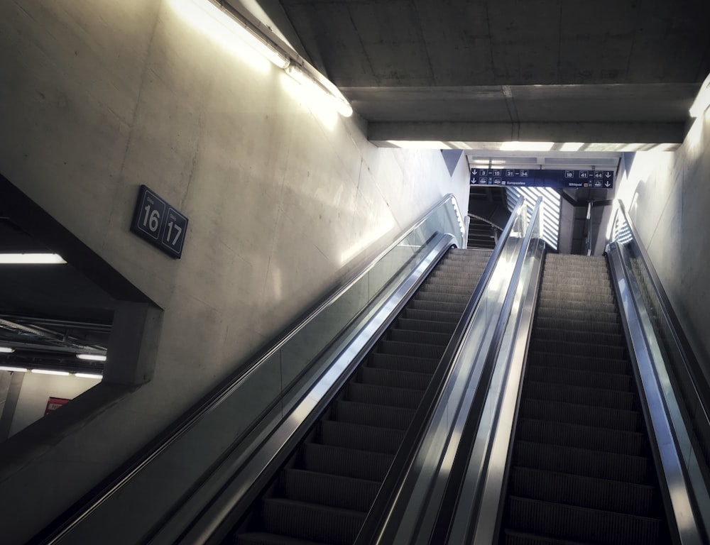 black and white escalator on white painted wall