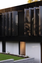 Close-up of a luxury residential exterior featuring dark navy panels and silver accents.