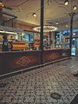 Elegant coffee shop counter with warm lighting and artisanal Mexican textiles in the background.