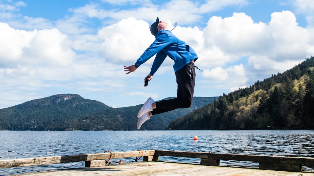 a man jumping off a dock into the air