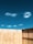 A close-up of a sturdy wooden fence with a clear blue sky in the background.
