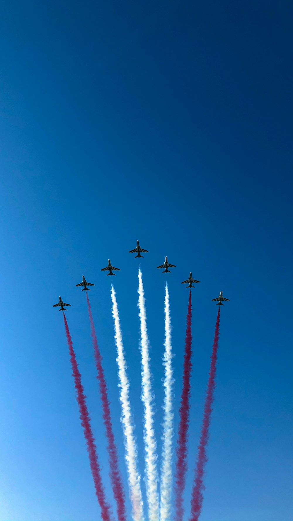 eight red and white jet planes in mid air