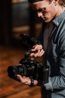 A professional filmmaker adjusting lighting equipment for a shoot.