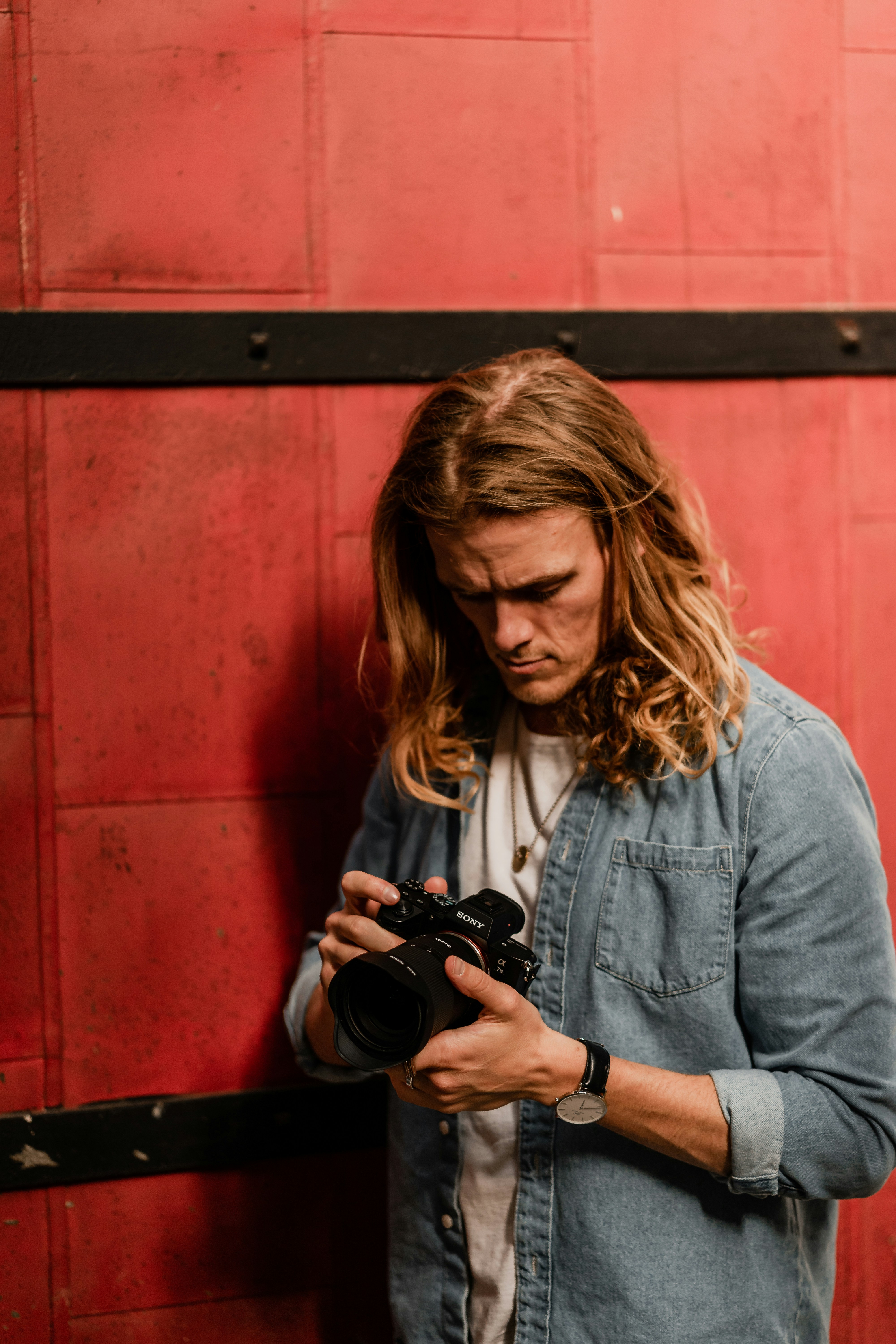 Frau in blauer Jeansjacke mit schwarzer DSLR-Kamera