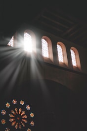 Sunlight streaming through stained glass windows inside the Shaarei Jerusalem synagogue.