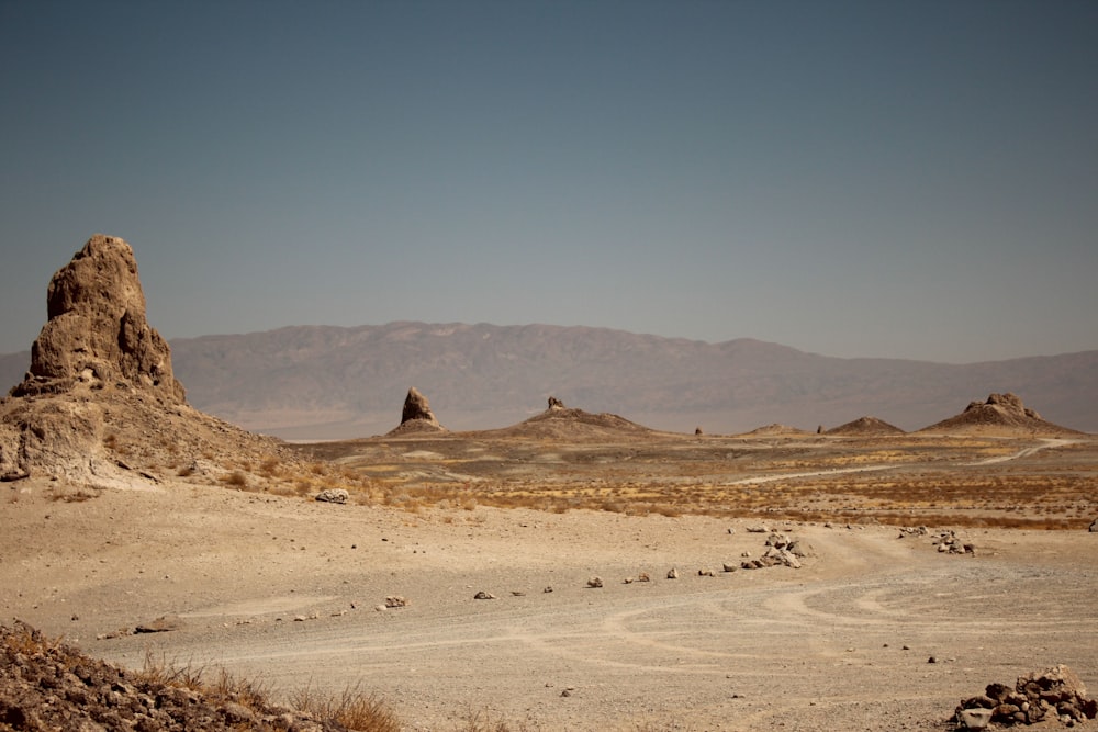 campo de areia marrom perto da montanha marrom durante o dia