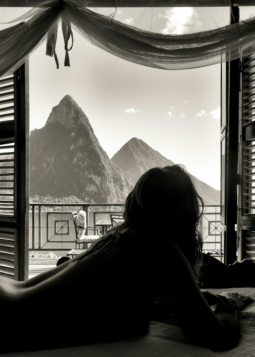 昼間に雪に覆われた山々を眺める女性のシルエット
