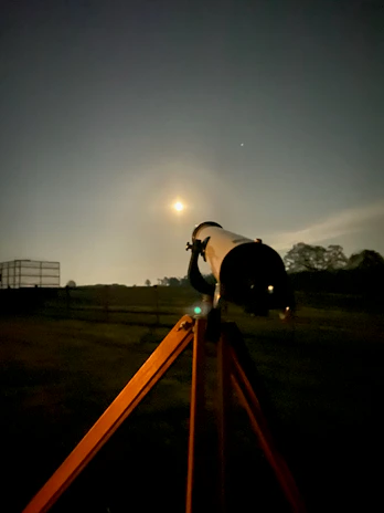 An astronomer silhouetted against a glowing full moon, adjusting their telescope.