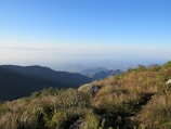A panoramic view from a mountain peak overlooking rolling hills and distant valleys.