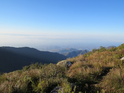 A panoramic view from a mountain peak overlooking rolling hills and distant valleys.