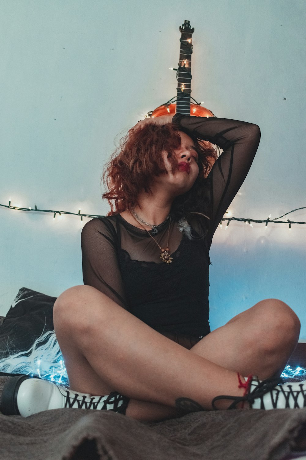 woman in black tank top holding red electric guitar