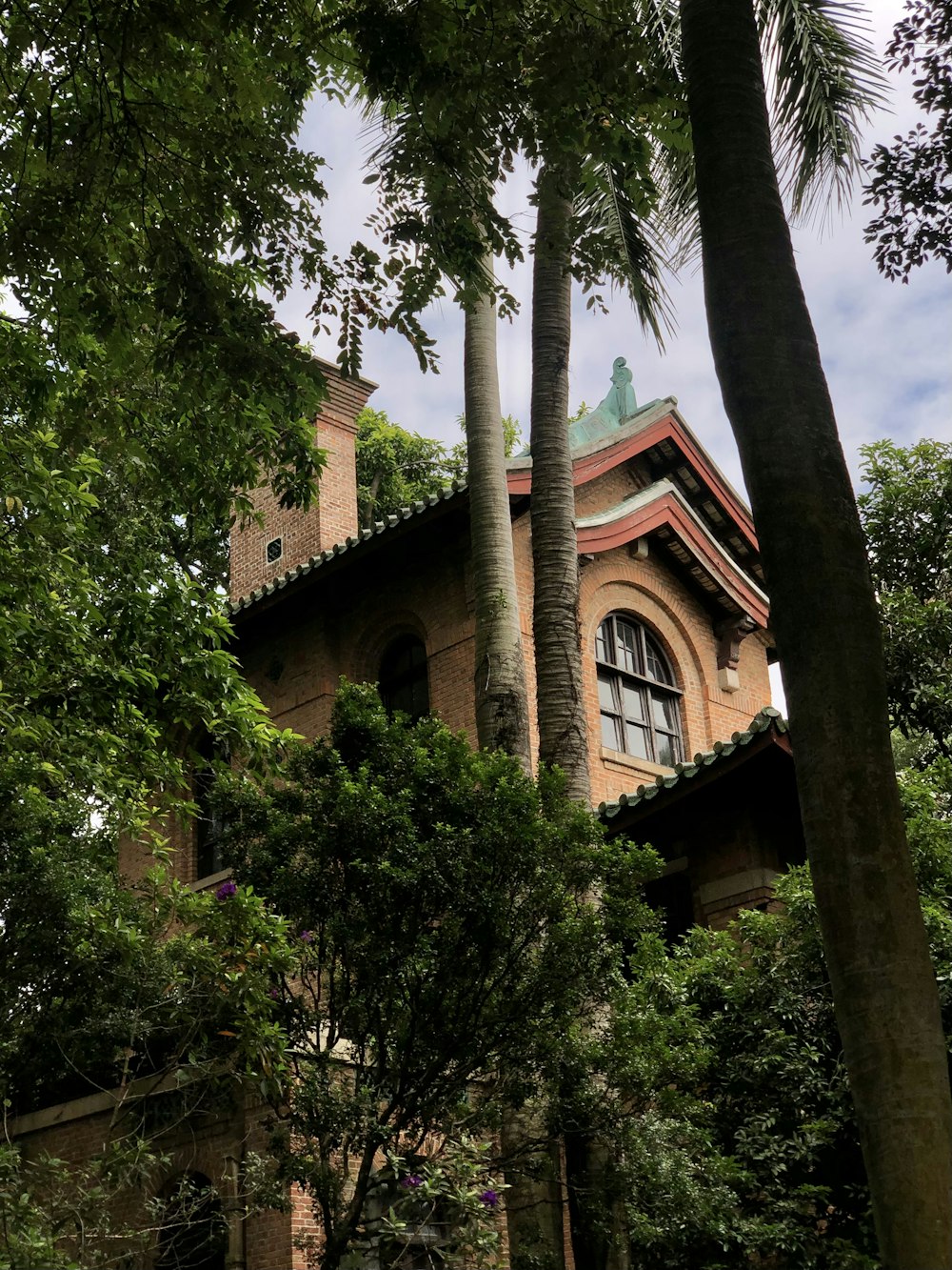 brown concrete building near green trees during daytime