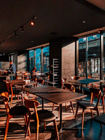 Bright and welcoming grand café area with wooden tables and soft lighting.