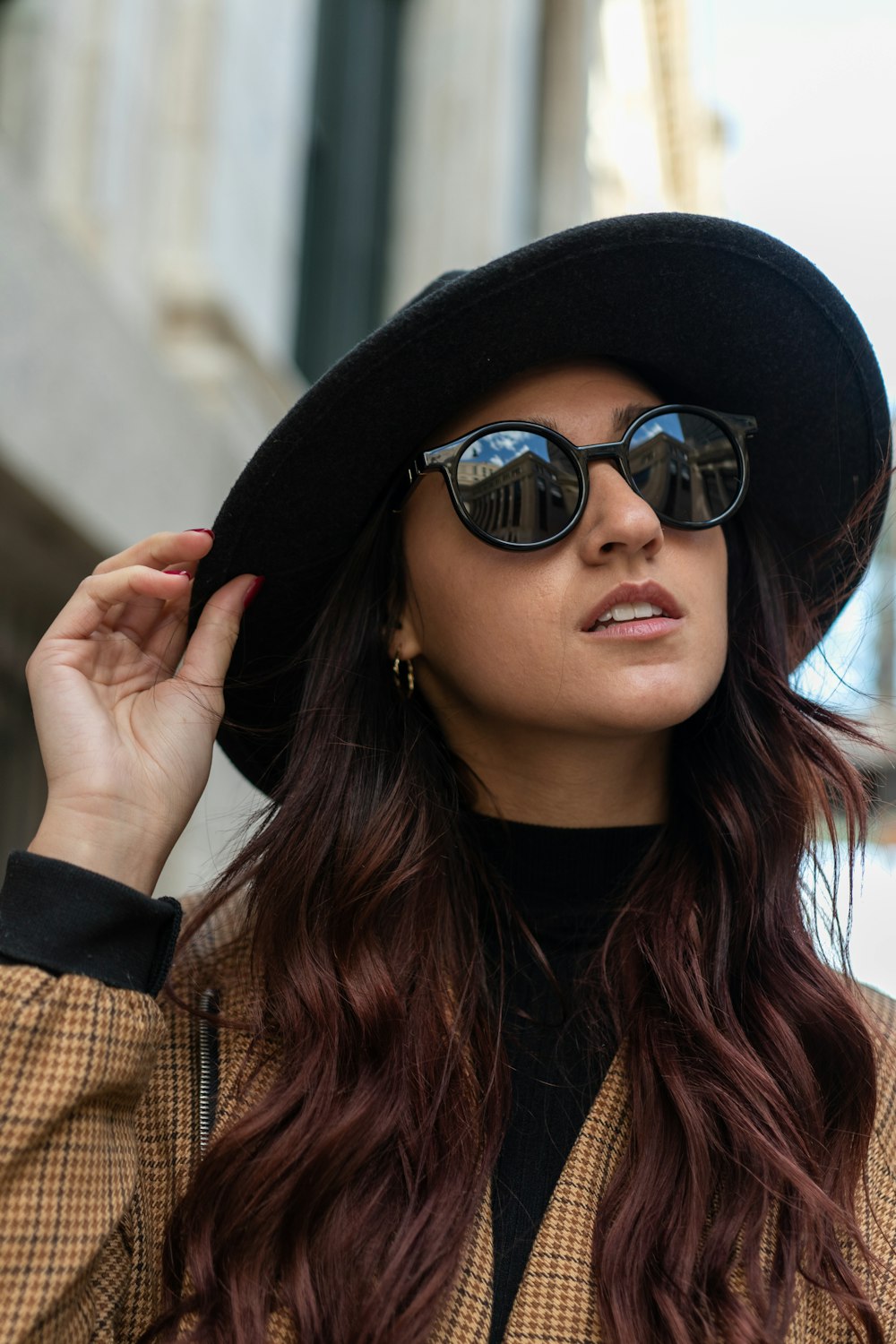 a woman wearing a black hat and sunglasses