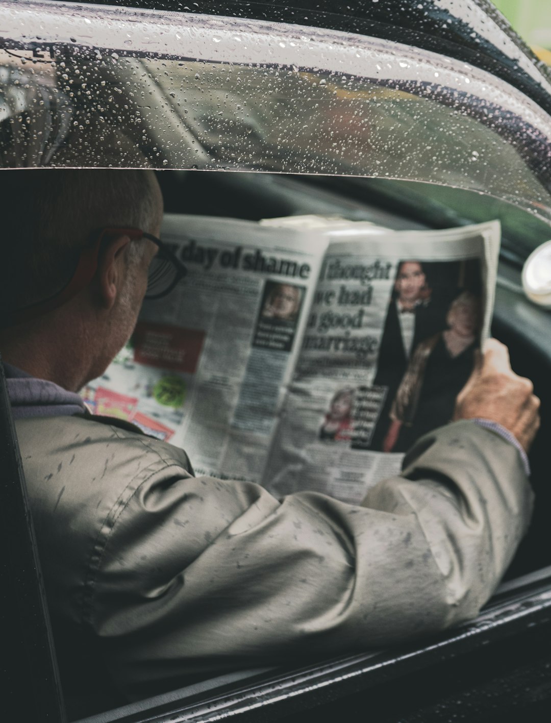 man in gray dress shirt holding newspaper