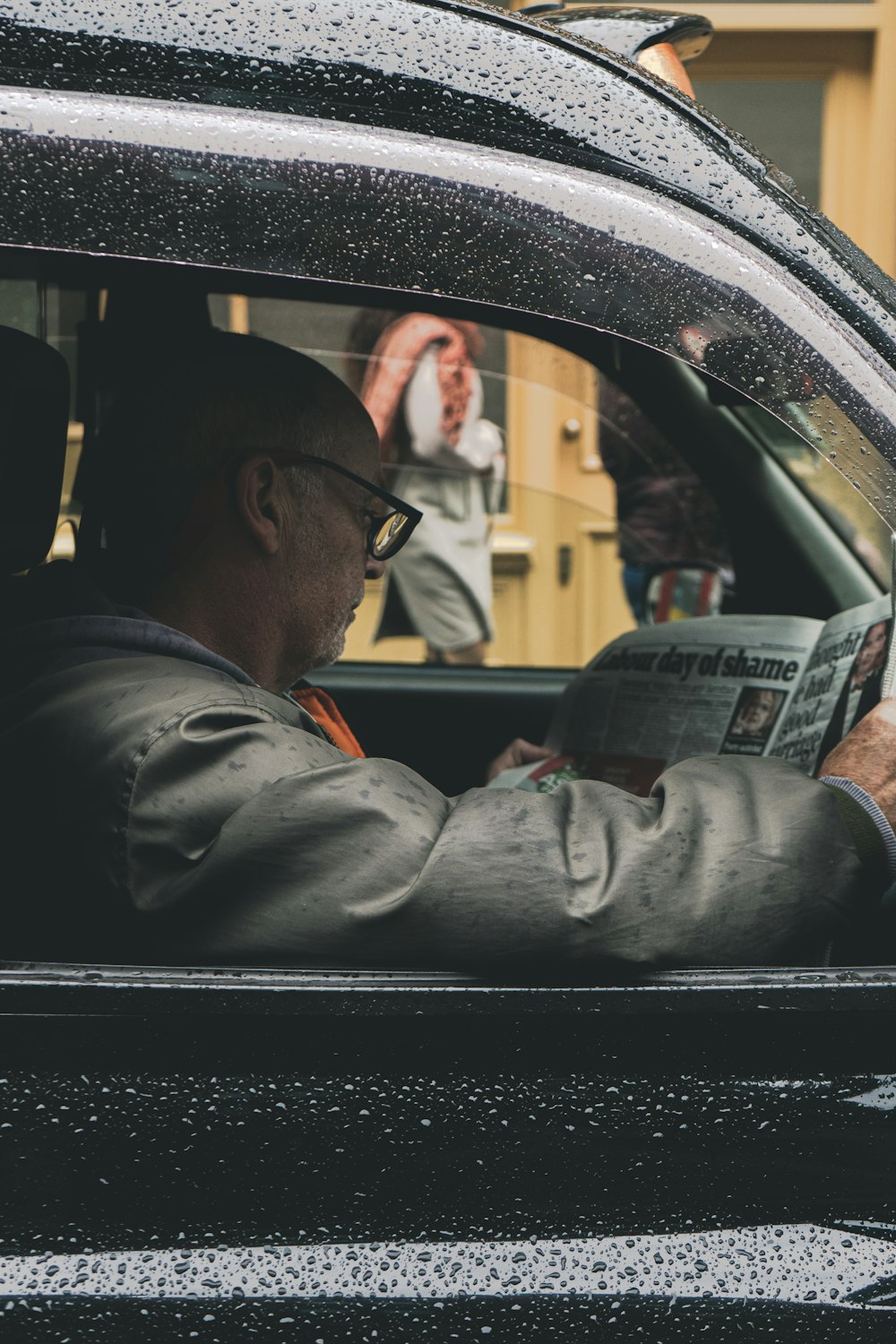 man in gray jacket driving car