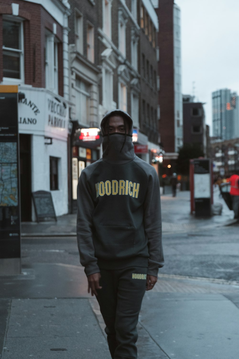 a man in a hoodie walks down the street