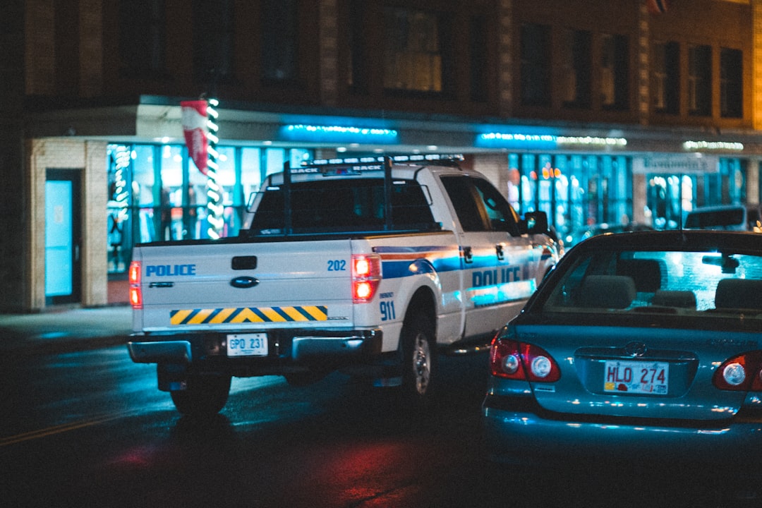 blue and white police car on road during nighttime