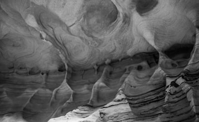 grayscale photo of rock formation layered teams background