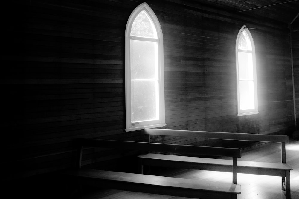 a black and white photo of two windows in a church