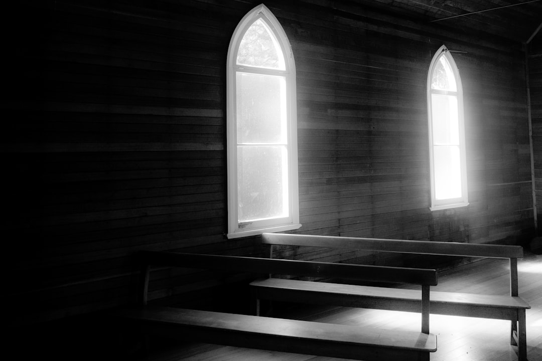 a black and white photo of two windows in a church