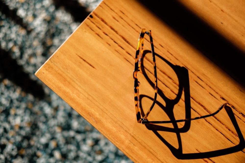 a pair of glasses sitting on top of a wooden table