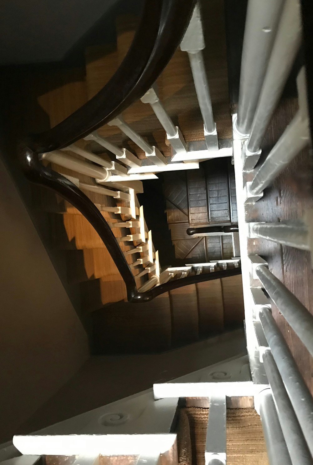 brown wooden staircase with white wooden railings