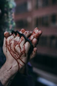 Close-up of the protagonist's hands gripping a cleaver stained with fresh blood.