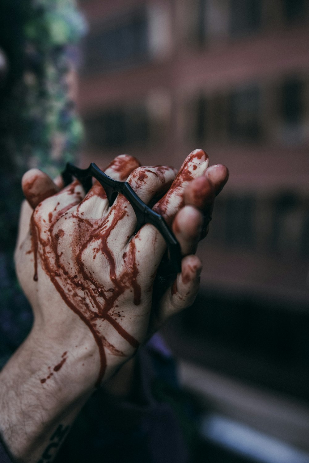 a man with blood on his hands holding a barbwire