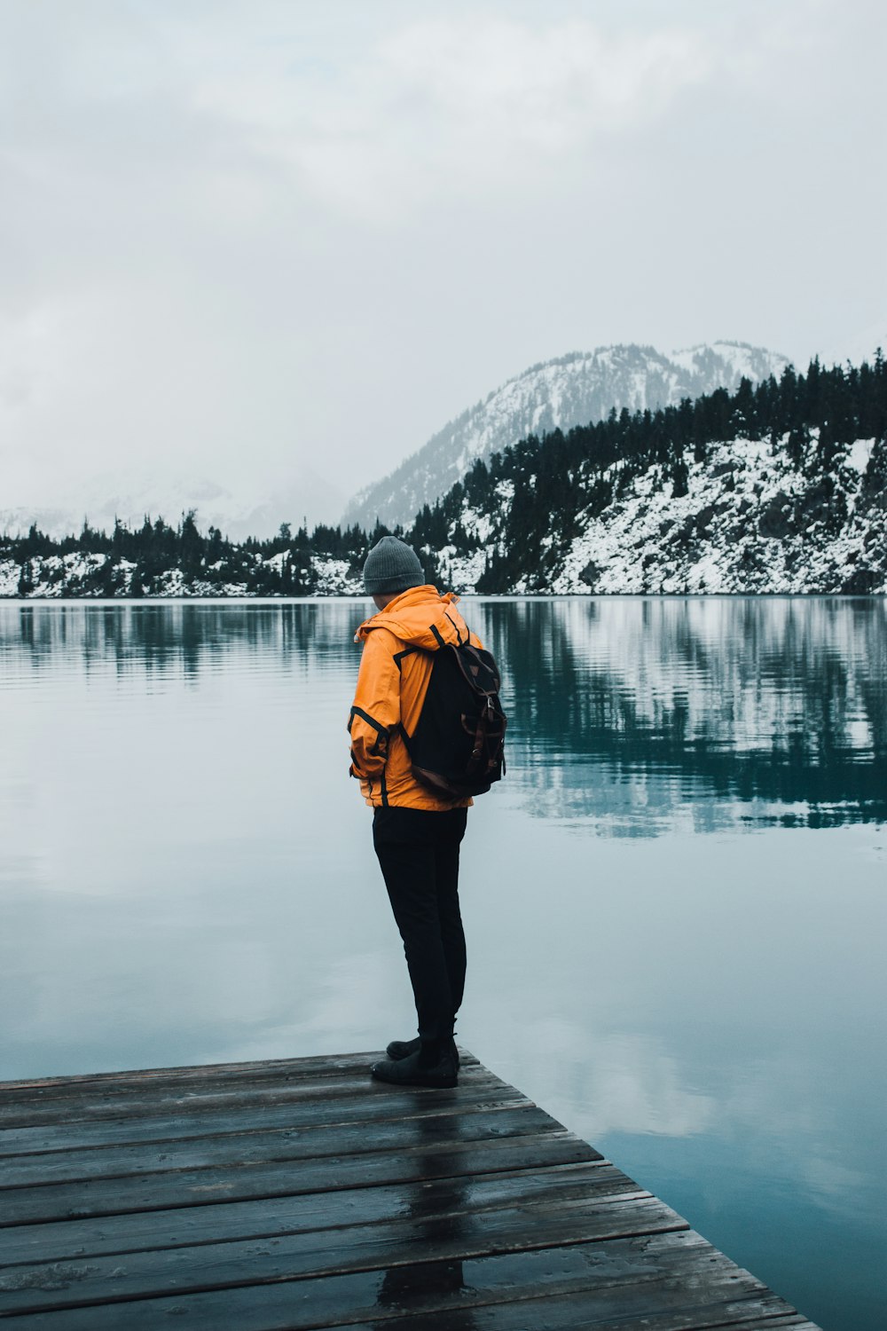 a person standing on a dock near a body of water