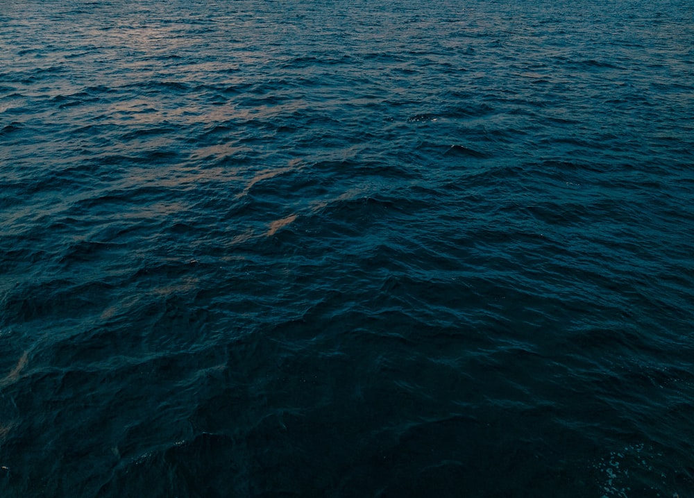 a large body of water with a sky in the background