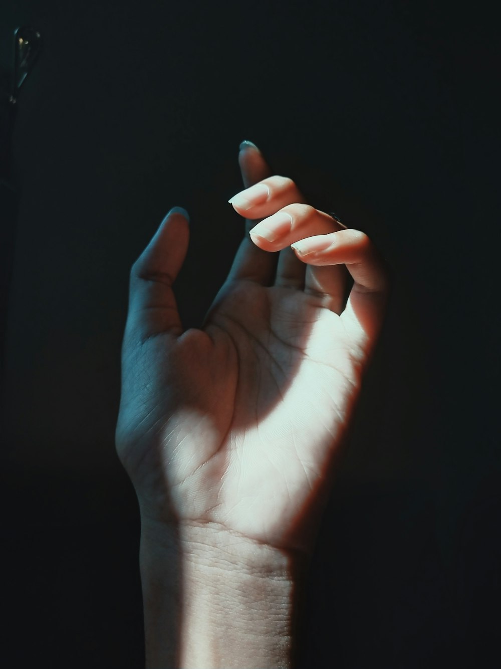 a person's hand holding a cigarette in the dark