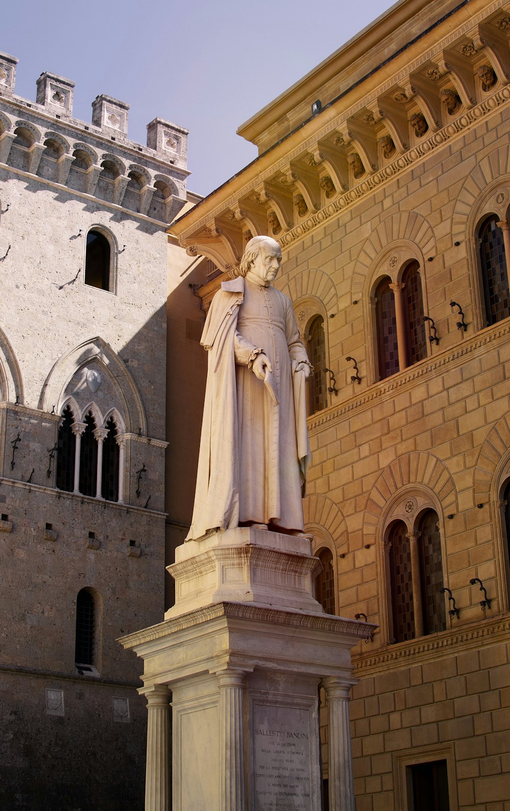 white statue of a woman in front of a building