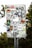 A metal sign has been covered with a variety of colorful and monochrome stickers featuring text, logos, and graphics. The stickers are layered and overlap each other, showcasing different designs and artistic styles. The background shows some greenery and tree foliage.