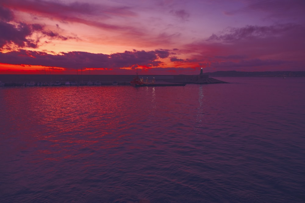 body of water under cloudy sky during sunset