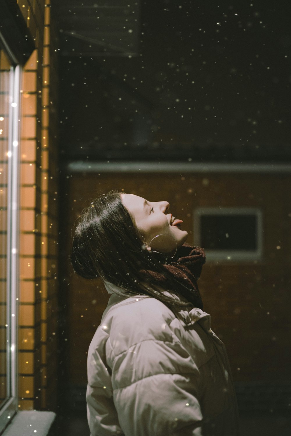 woman in white shirt looking out the window