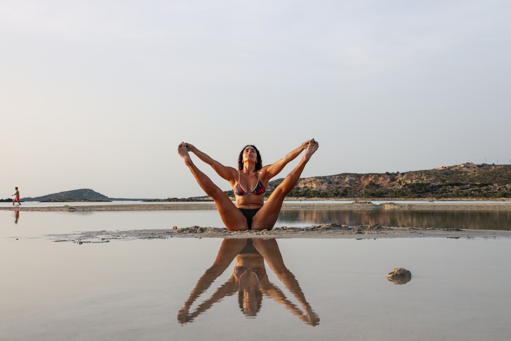 2 women in bikini jumping on beach during daytime