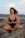 woman in black tank top sitting on gray rock during daytime