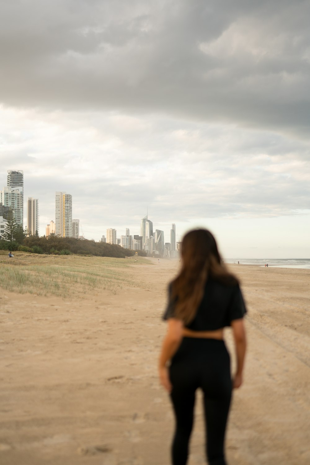 woman in black shirt walking on beach during daytime